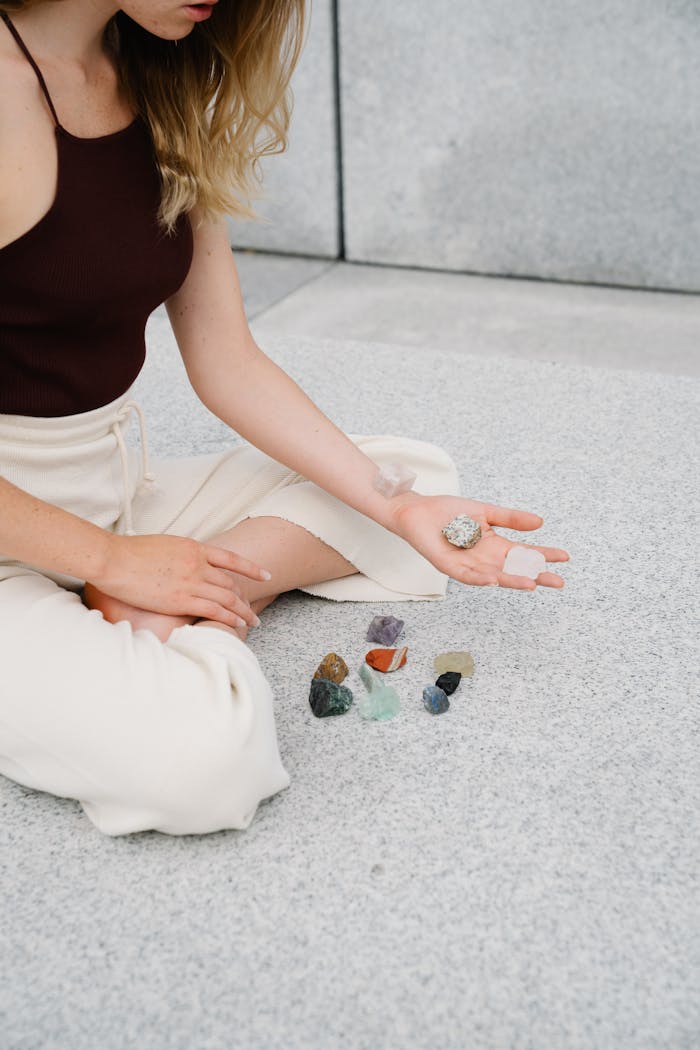 A young woman practicing mindfulness, holding crystals in a serene, minimalist setting.
